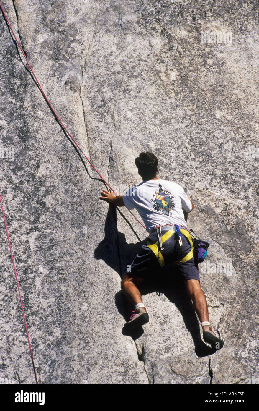 Rockclimber is belayed up a rock face, British Columbia, Canada. Stock Photo