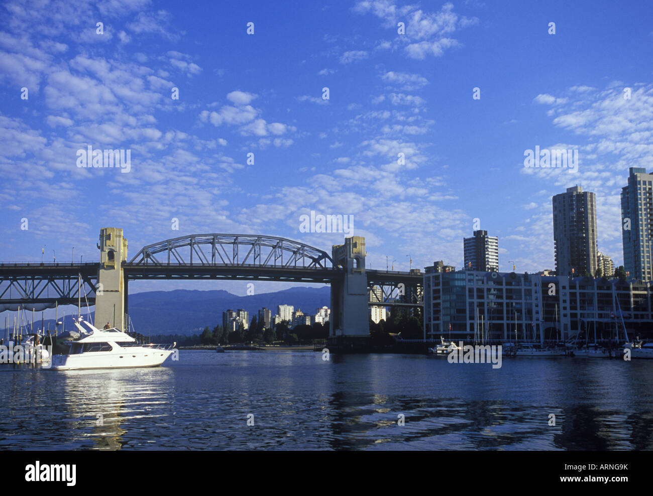 Burrard bridge frames view to West End, with yacht underway, Vancouver, British Columbia, Canada. Stock Photo
