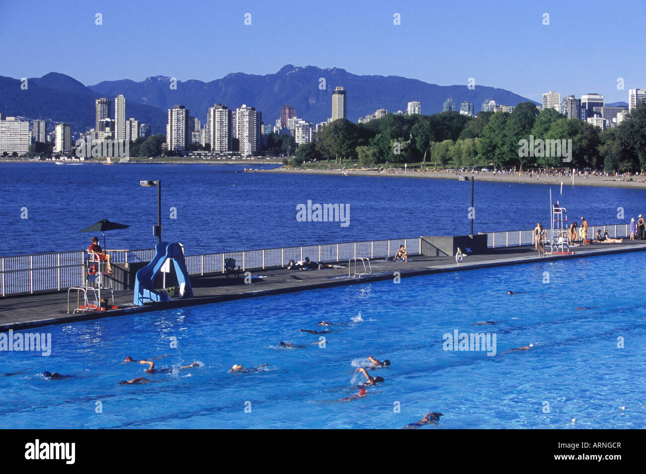 People enjoying the Kitsilano Outdoor Swimming Pool, English Bay and downtown Vancouver beyond, Vancouver, British Columbia, Can Stock Photo