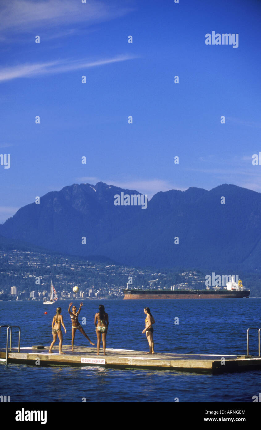 Girls play volleyball on a dock in English Bay along Kitsilano Beach