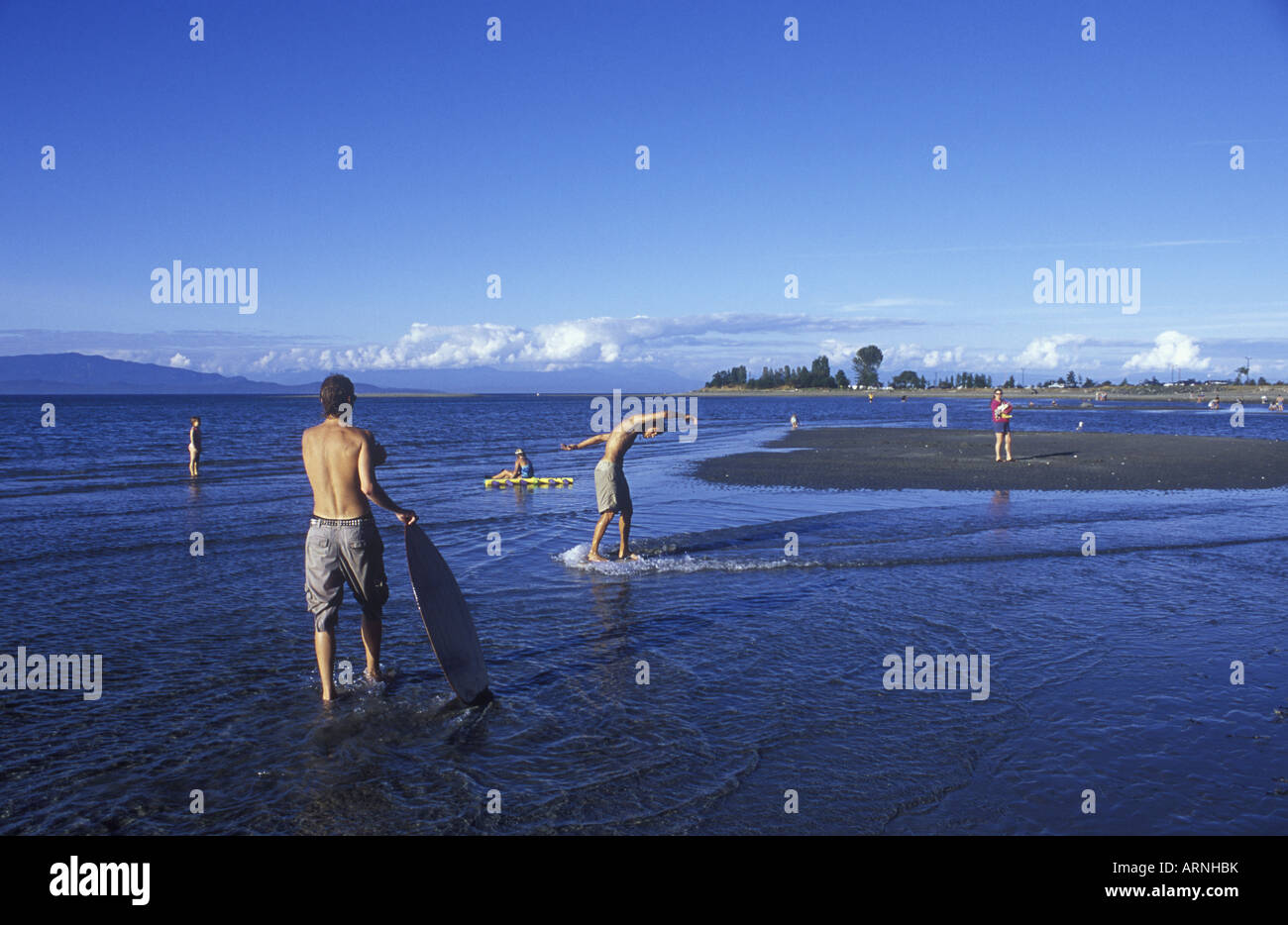 Parksville Beach Young men skim boarding, Vancouver Island, British