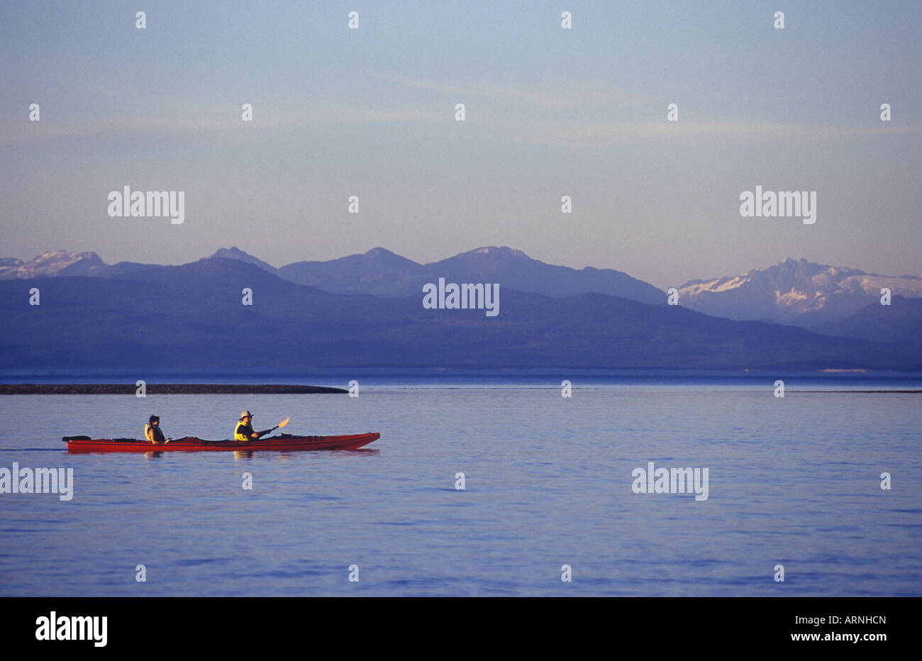 Parksville Beach Double kayak paddles on Strait. Coast Range in