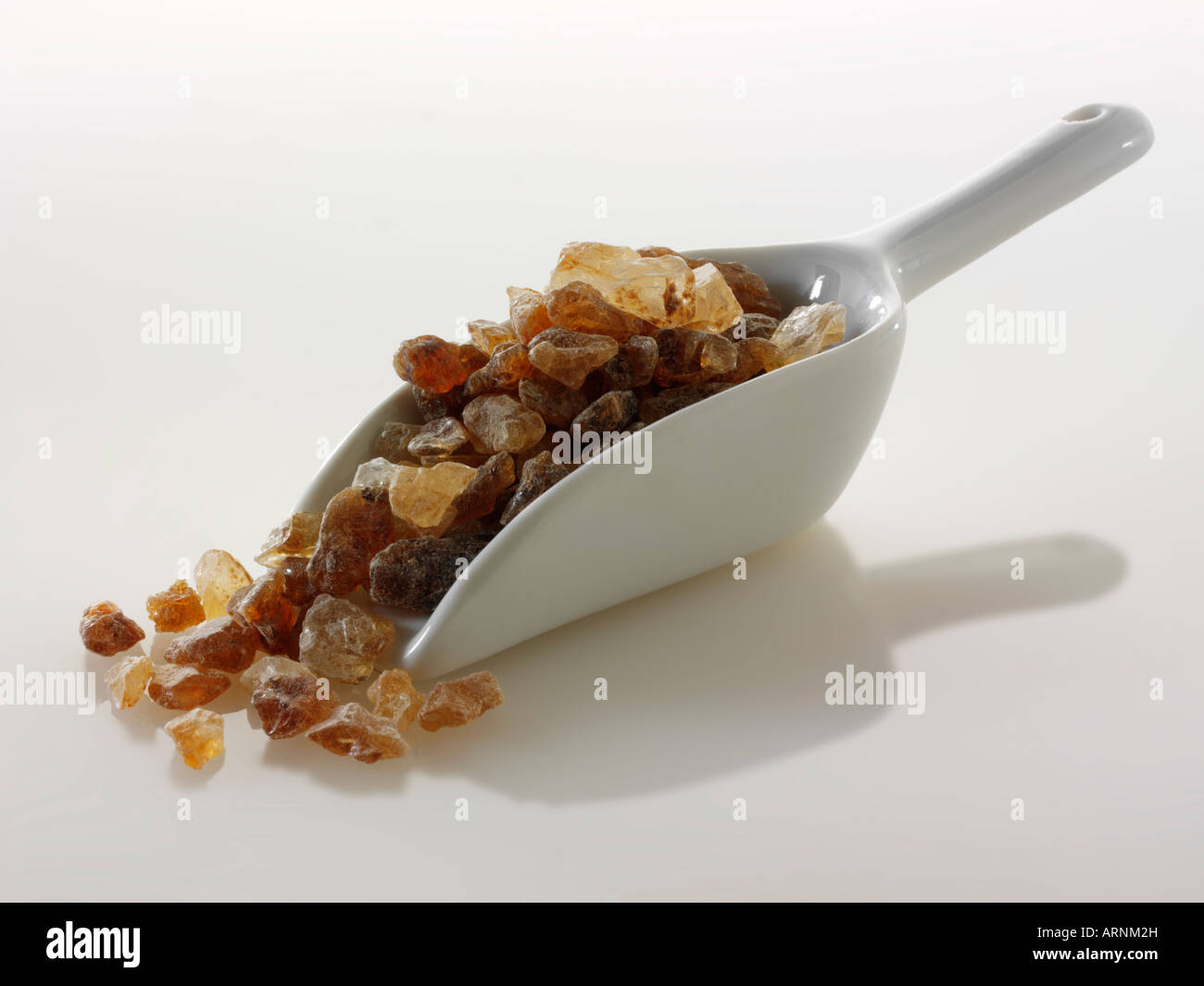 Amber sugar crystals still life against a white background Stock Photo