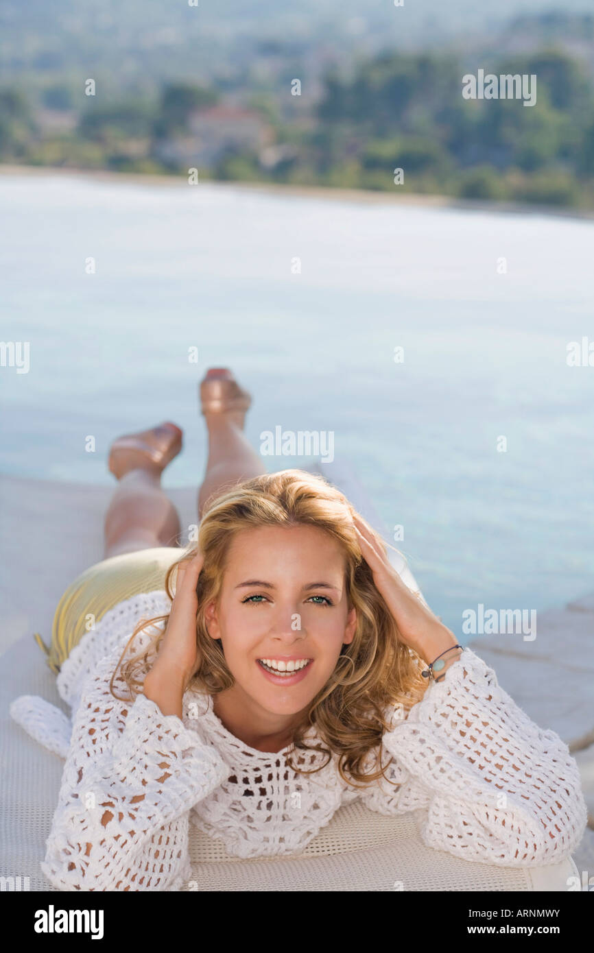 Woman relaxing by a pool Stock Photo