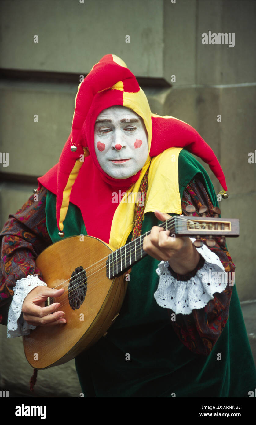 Busker dressed as a Joker and playing the lute during the Edinburgh Festival Fringe Stock Photo
