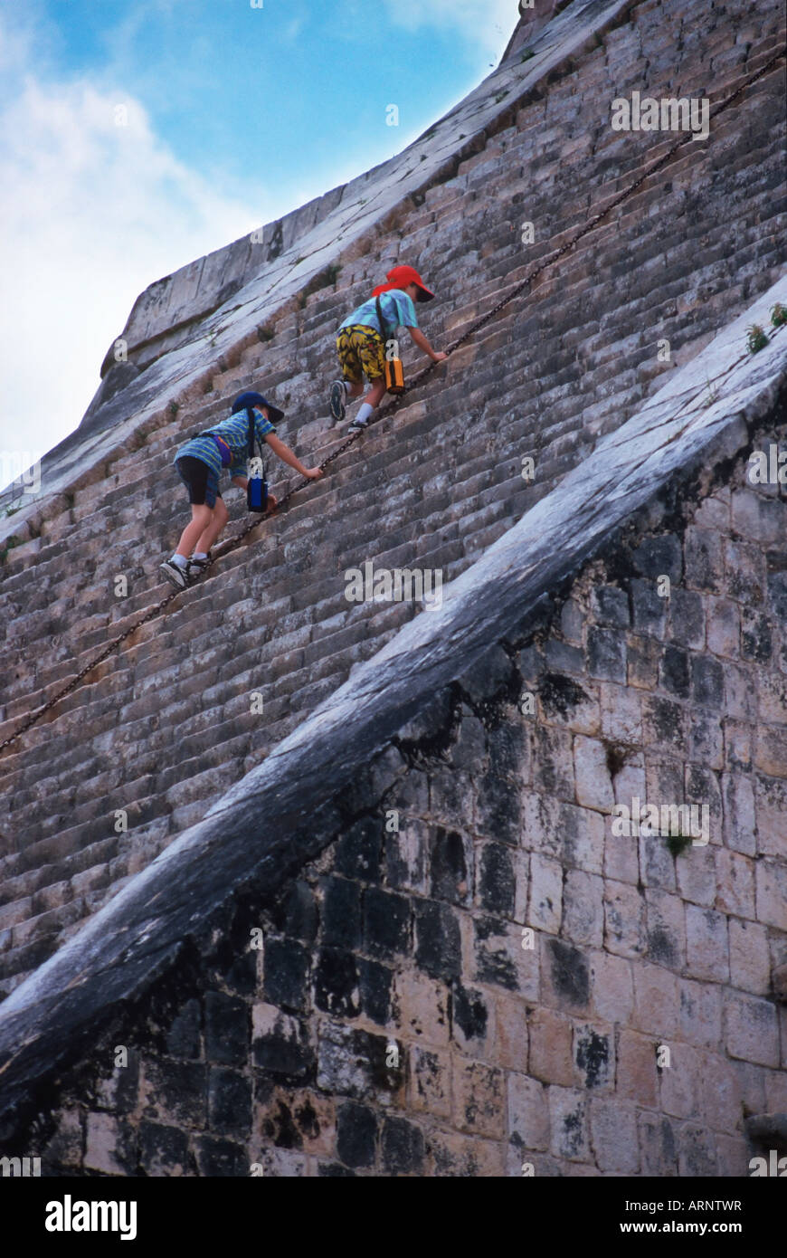 Mexico, Yucatan Peninsula at Chichen Itza, boys climb pyramid Stock