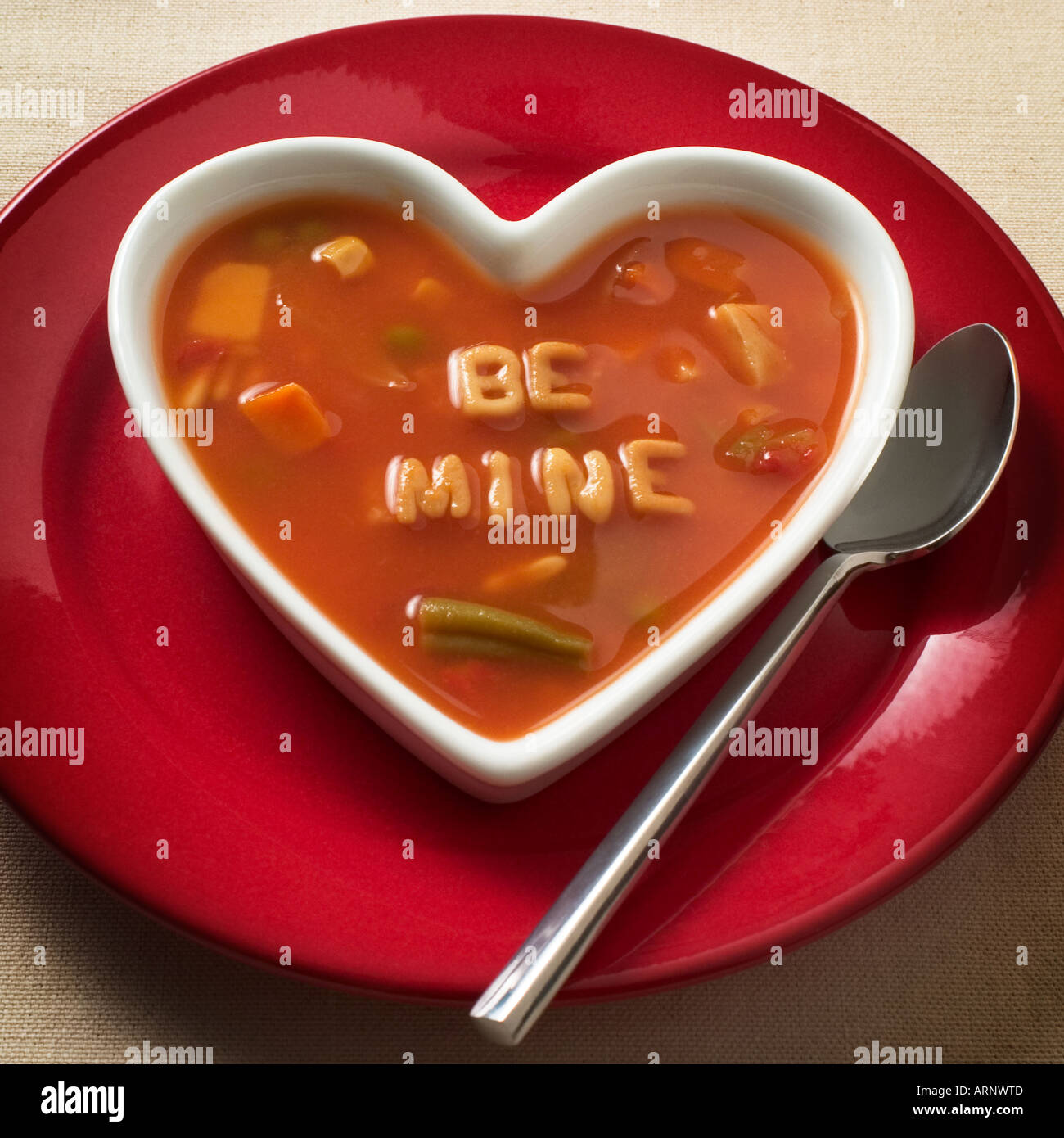 Heart shaped bowl of alphabet soup that reads: be mine Stock Photo