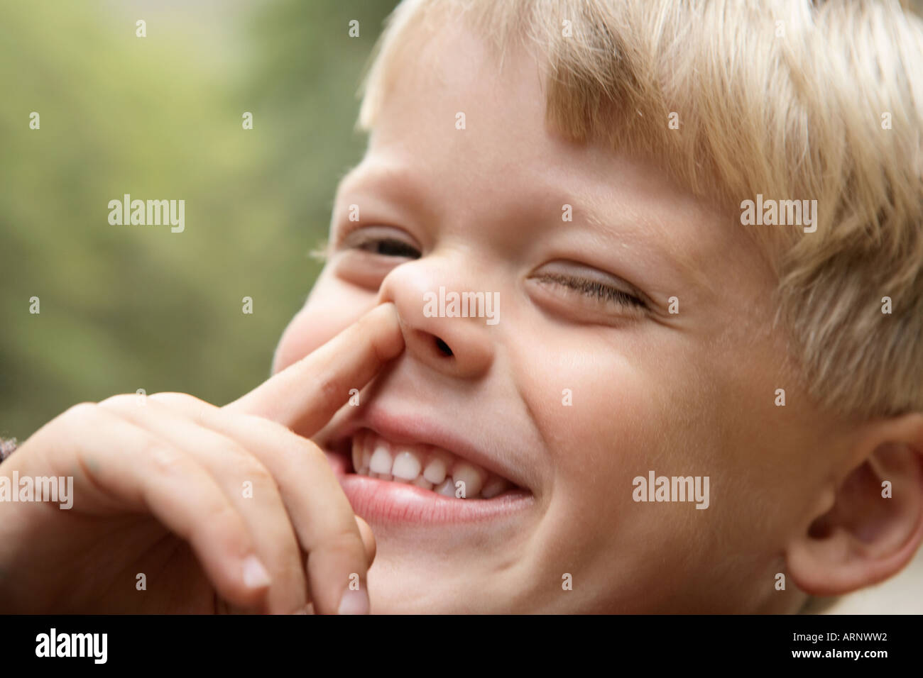 Young boy sticking finger up his nose Stock Photo