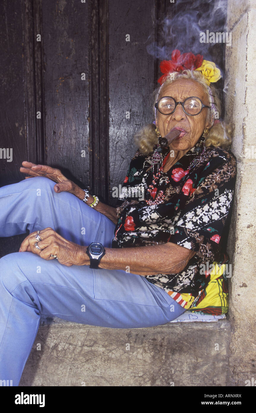 Older woman smoking cigar, Plaza de la Cathedral area, Havana Vieja, Cuba Stock Photo