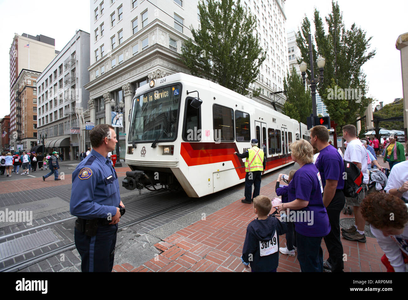 A Group of Pedestrians stop for the MAX train in Portland, Oregon. Stock Photo