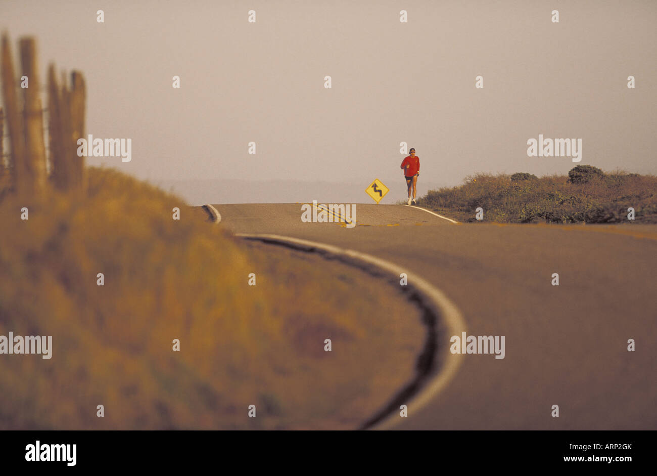 USA, California, San Simeon, runner on highway at dusk Stock Photo