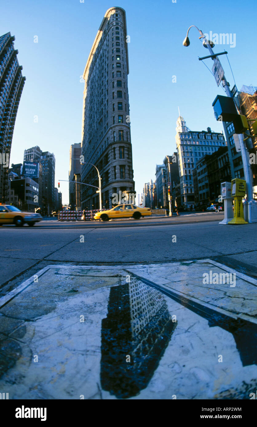 USA, New York City, Flatiron Bldg and yellow cabs. image of same on sidewalk Stock Photo