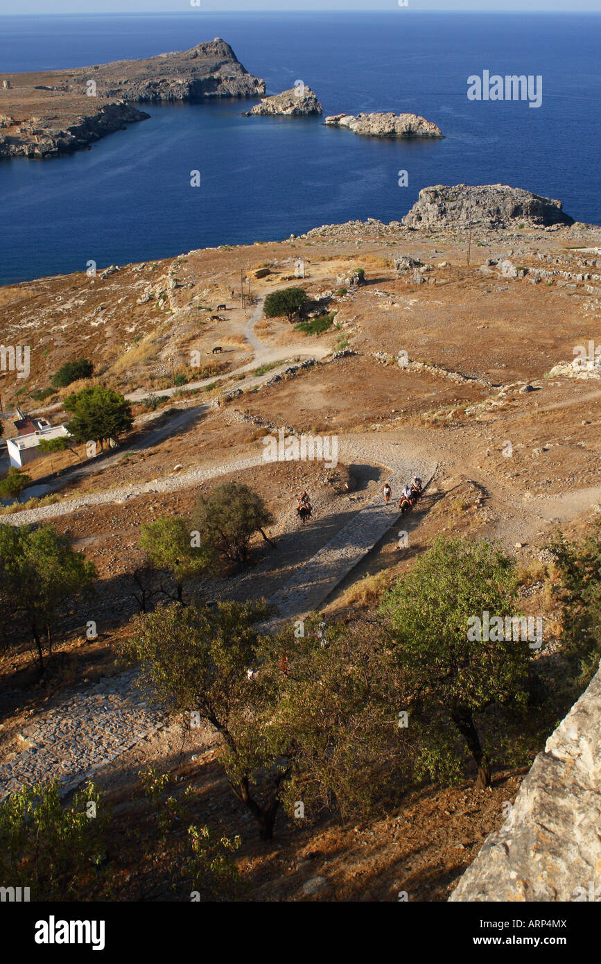 View down from the Acropolis Tourists take the Donkey Ride up the path to get to the top Lindos Rhodes Greece Stock Photo