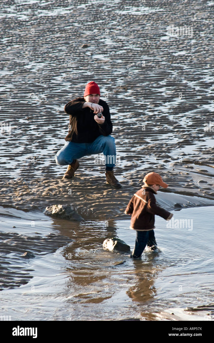 Boy child 4 5 years paddling playing sea water wet cloths seaside sea water outdoors day people winter scene view MMC Stock Photo