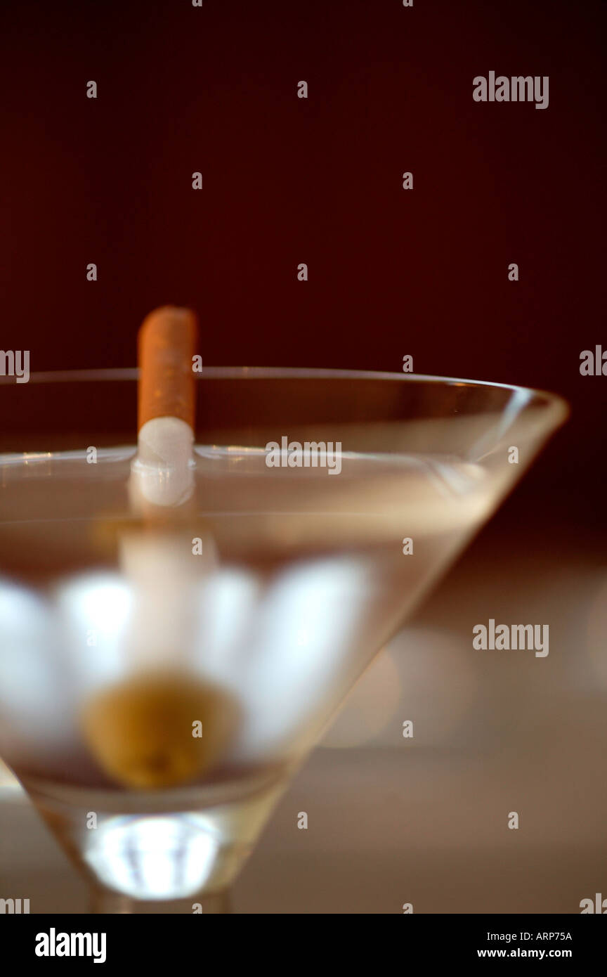 a martini with a cigarette as a garnish tooth pick Stock Photo