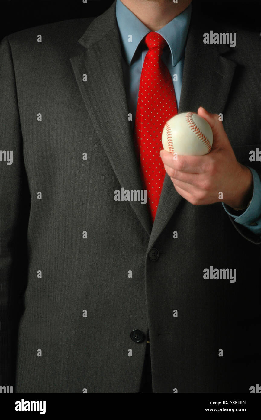Sports executive in suit holding a baseball ready for a sales pitch