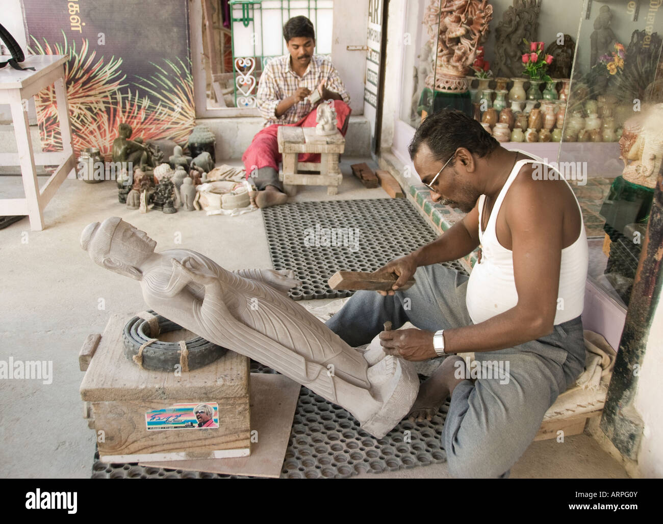 A skilled artisan carving a Buddha statue from stone in Mamallapuram in Tamil Nadu India Stock Photo