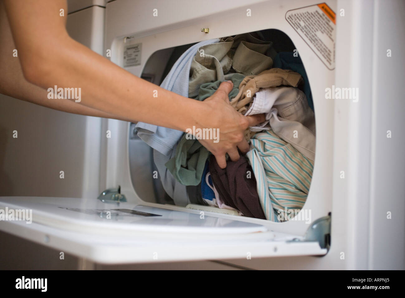 Removing dry clothes from dryer hires stock photography and images Alamy
