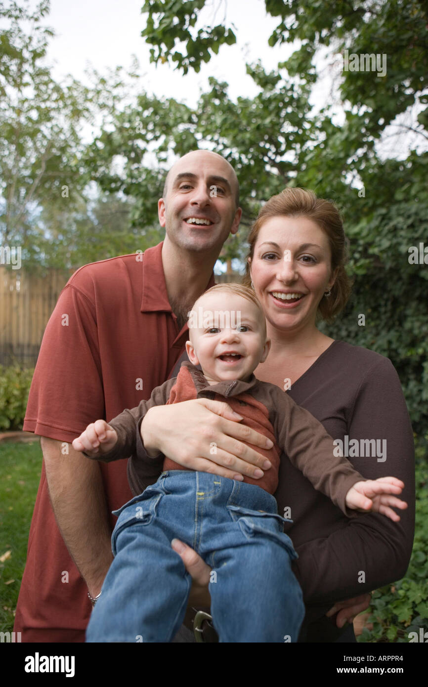 happy family with infant son smiling for camera in backyard Stock Photo