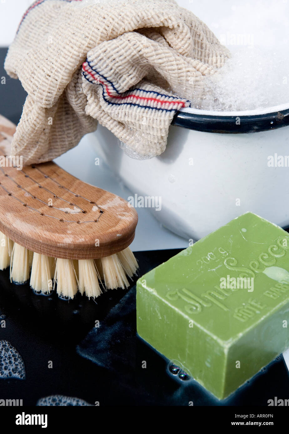 Cleaning with a traditional wooden scrubbing brush, household soap, traditional cloth with a vintage enamel bowl Stock Photo