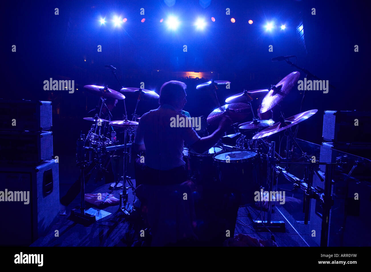 Drummer Matt Letley of Status Quo plays drums under blue lights on