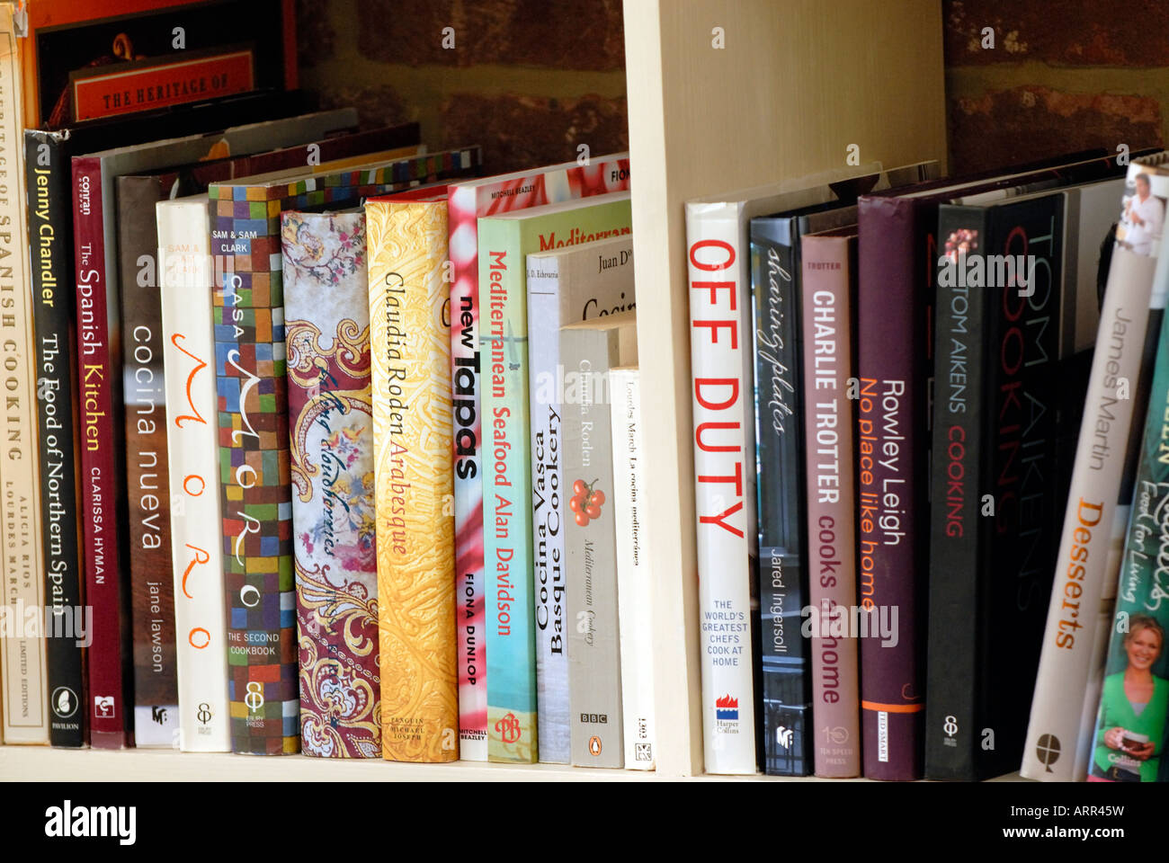 a row of cookery books on a shelf in a large country kitchen covering various all sorts of