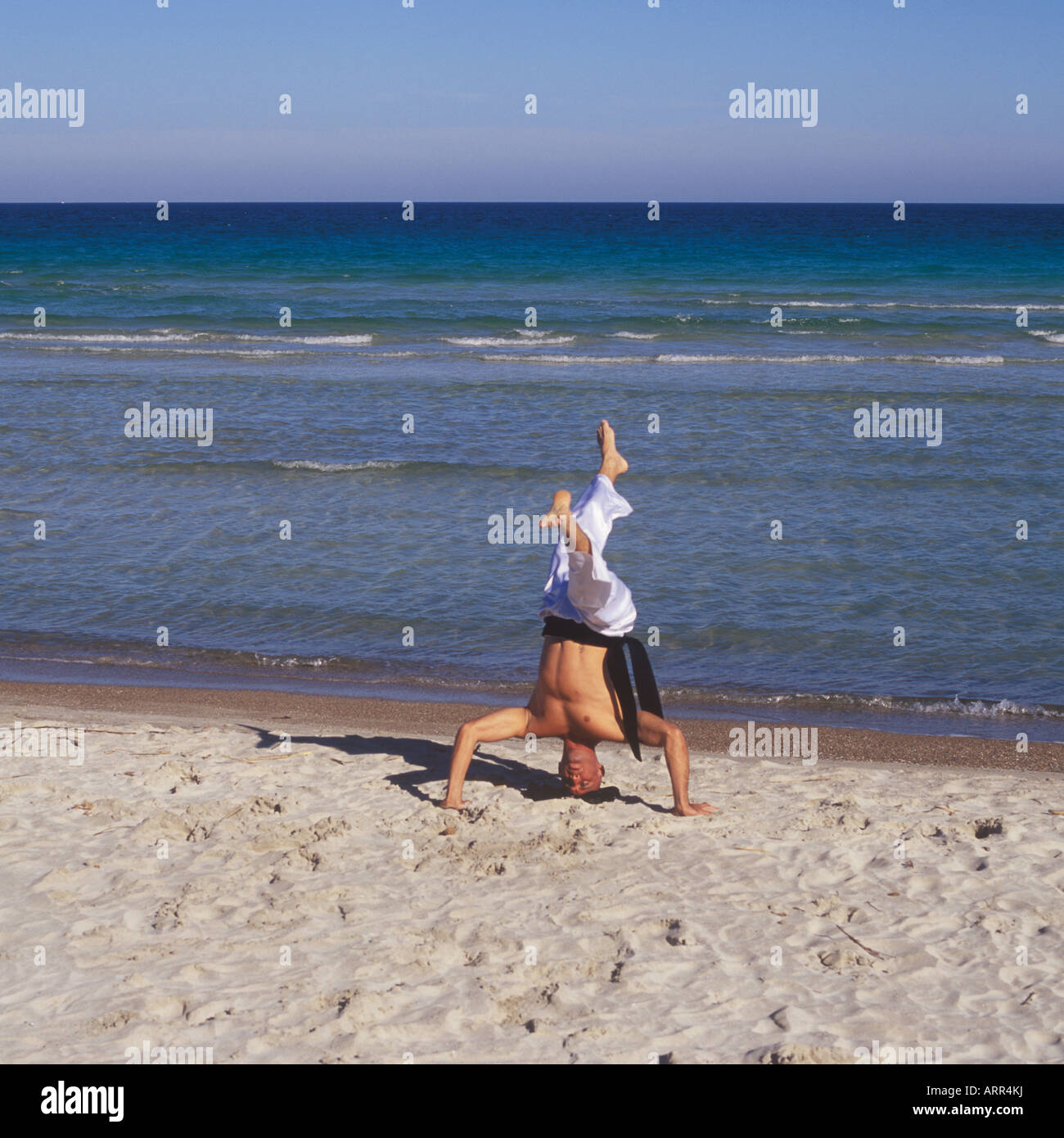 Professional Tai Chi and Kong Fu instructor undertaking workout on beach in Mallorca, Balearic Islands, Spain. Stock Photo