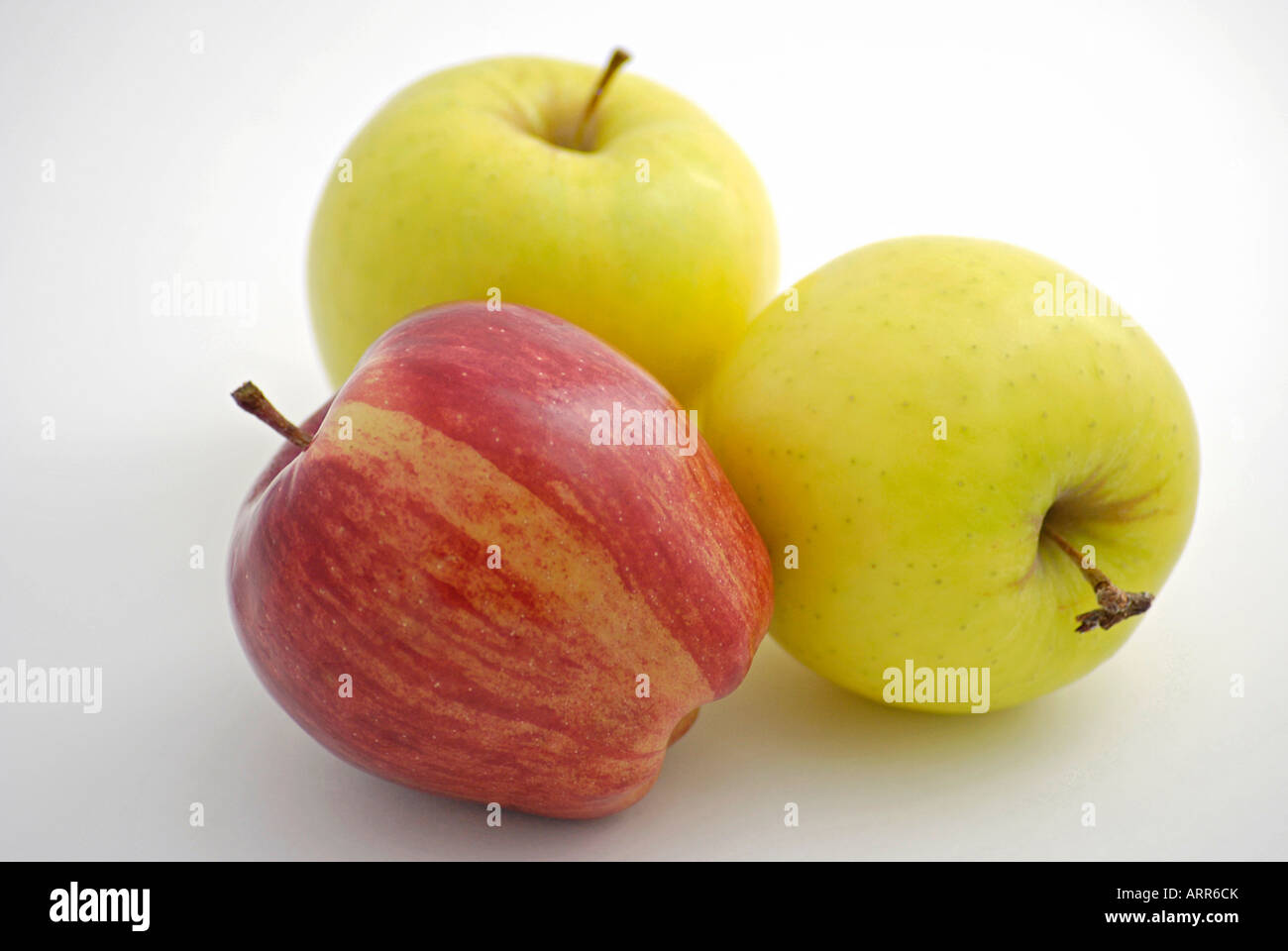 A Red Delicious apple and two Golden Delicious Apples Stock Photo