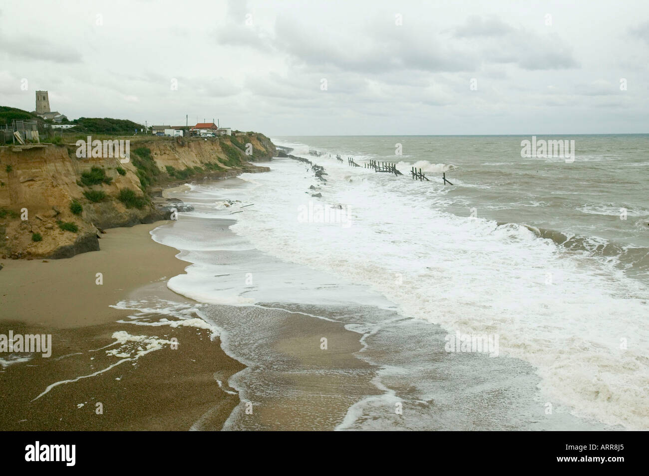 buildings left perilously close to the edge by coastal erosion, in Happisburgh, Norfolk, UK Stock Photo