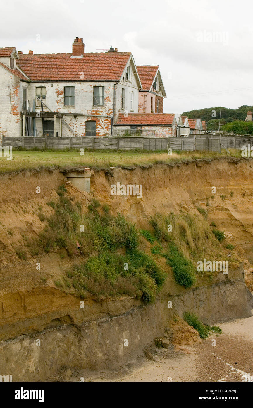 buildings left perilously close to the edge by coastal erosion, in Happisburgh, Norfolk, UK Stock Photo