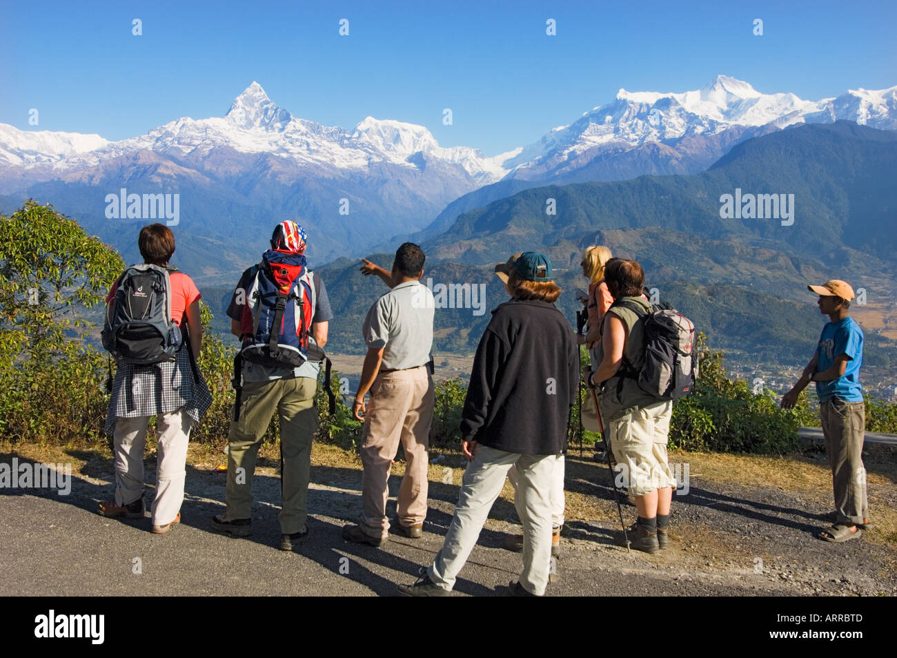 trekking tourists being taught about landscape nature by nepali guide Pokhara sarangkot outlook Machhapuchare Himalayan NEPAL Stock Photo