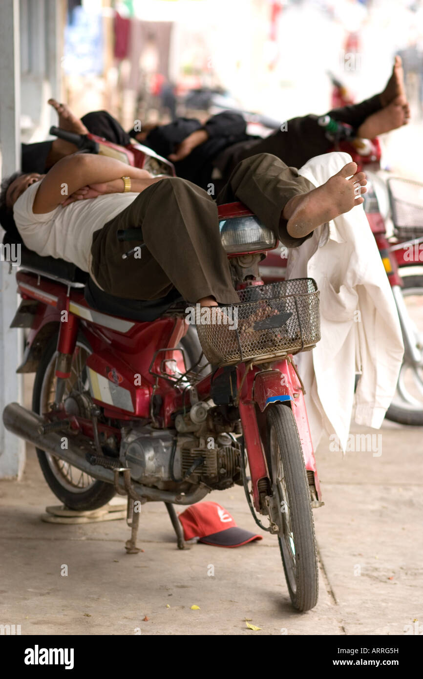 Moto drivers sleeping on their bikes during the afternoon Phnom Penh