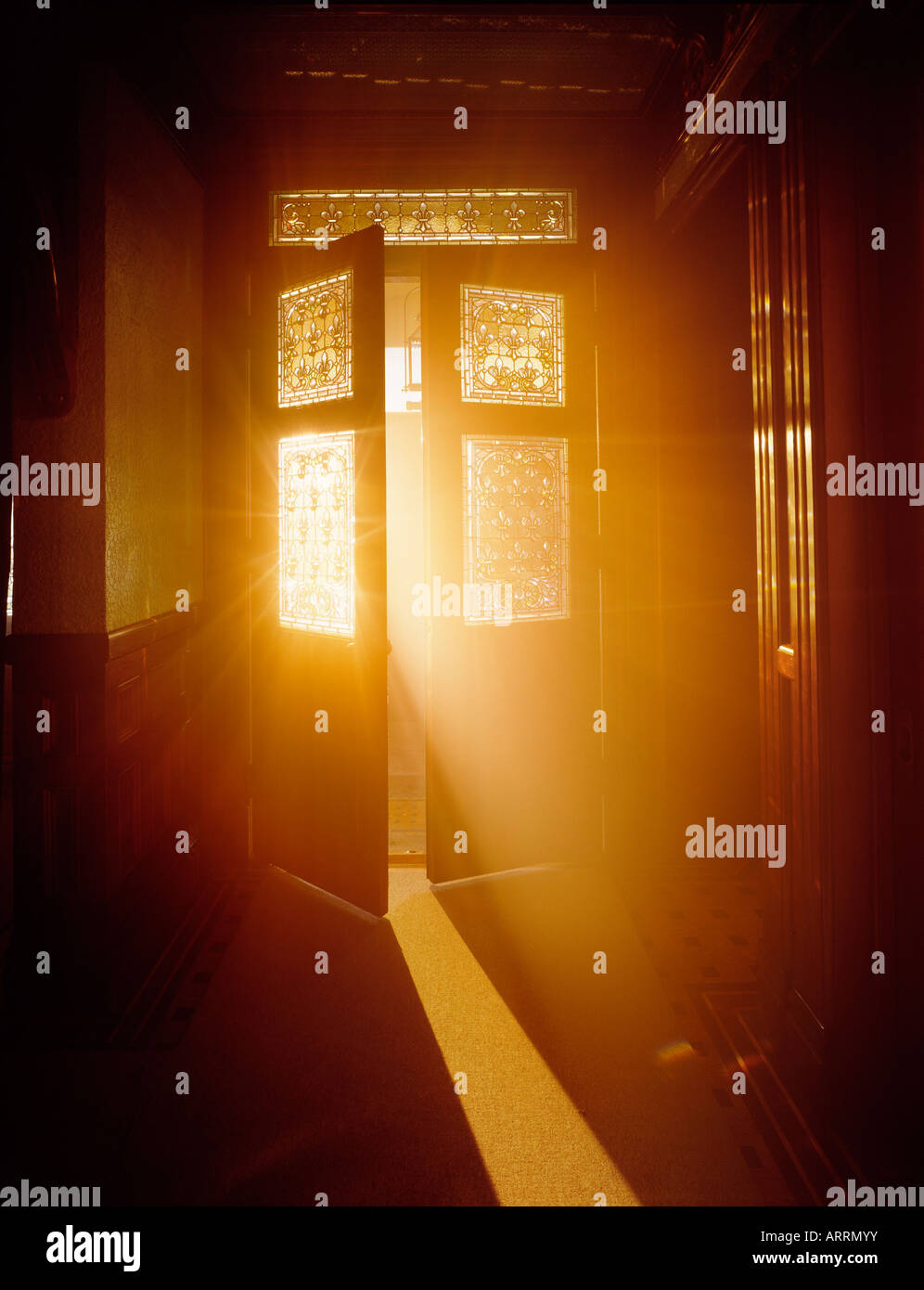 Golden light streaming through open door Stock Photo