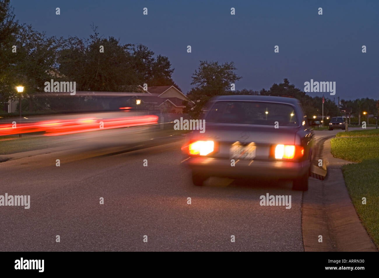 car drag racing in upscale residential area at night Stock Photo