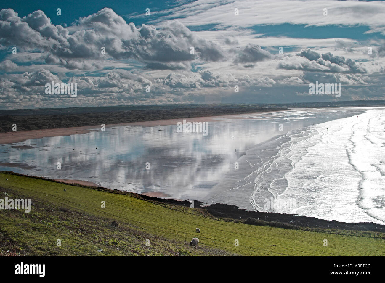 Reflections of the clouds in the wet sand at low tide. Stock Photo