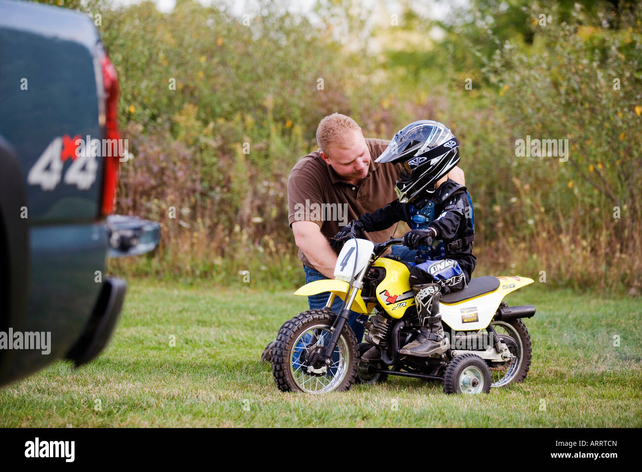 Son riding motorcycle with Father Stock Photo Alamy