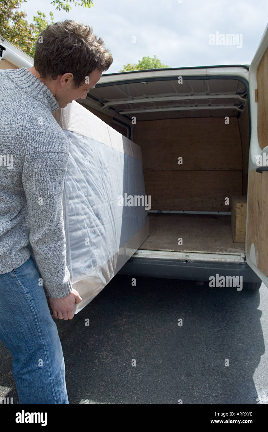 Man moving mattress from van Stock Photo Alamy