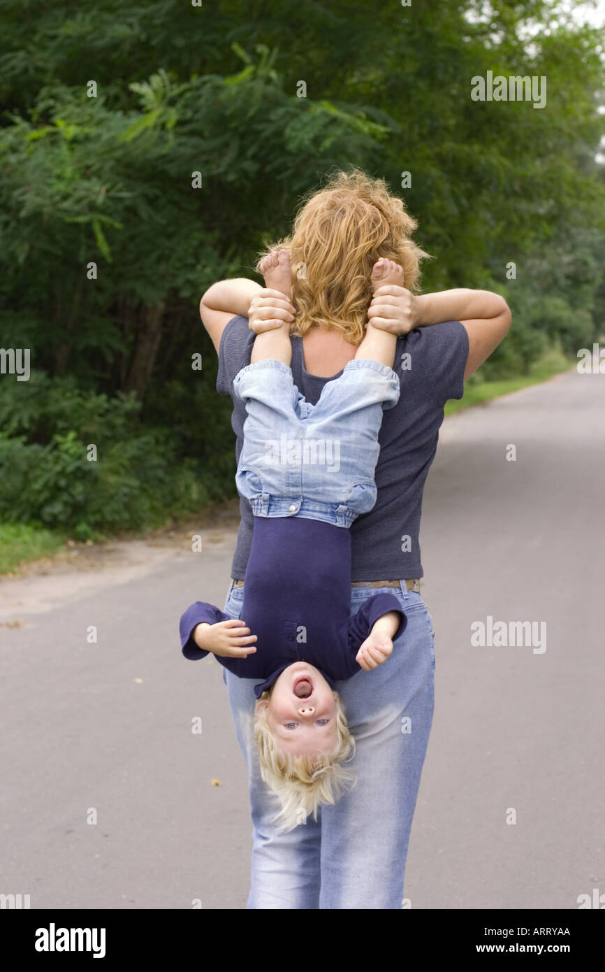 child carried head down Stock Photo - Alamy