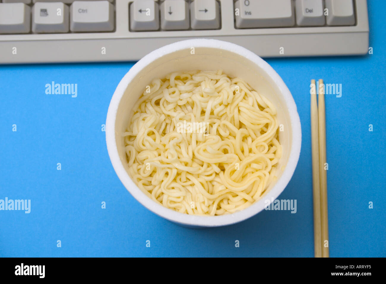instant noodles cup and chopsticks on table with keyboard Stock Photo