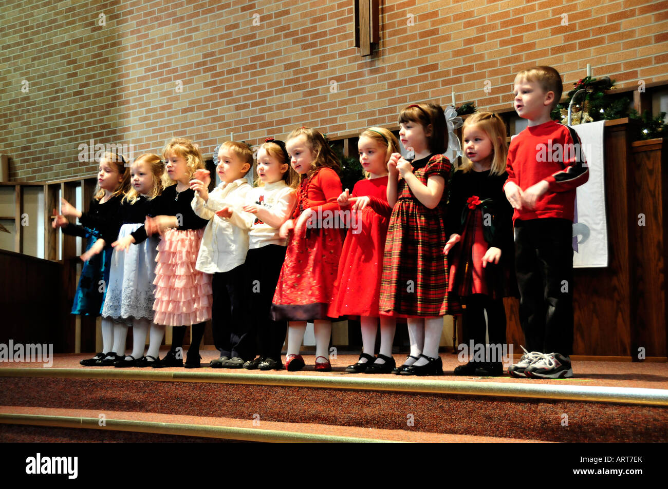 4 four year old pre school children hold recital performance for parents Stock Photo
