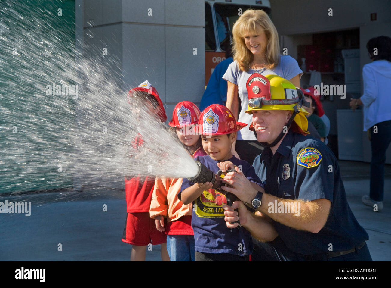 An elementary school boy gets a chance to spray a fire hose Stock Photo