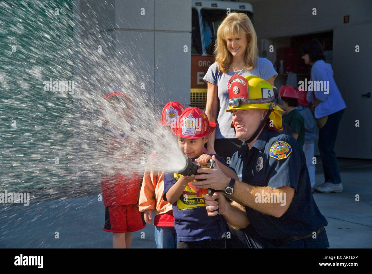 An elementary school boy gets a chance to spray a fire hose Stock Photo