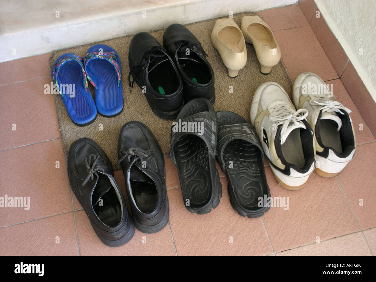 shoes on doormat outside asian household door neatly arranged Stock Photo -  Alamy