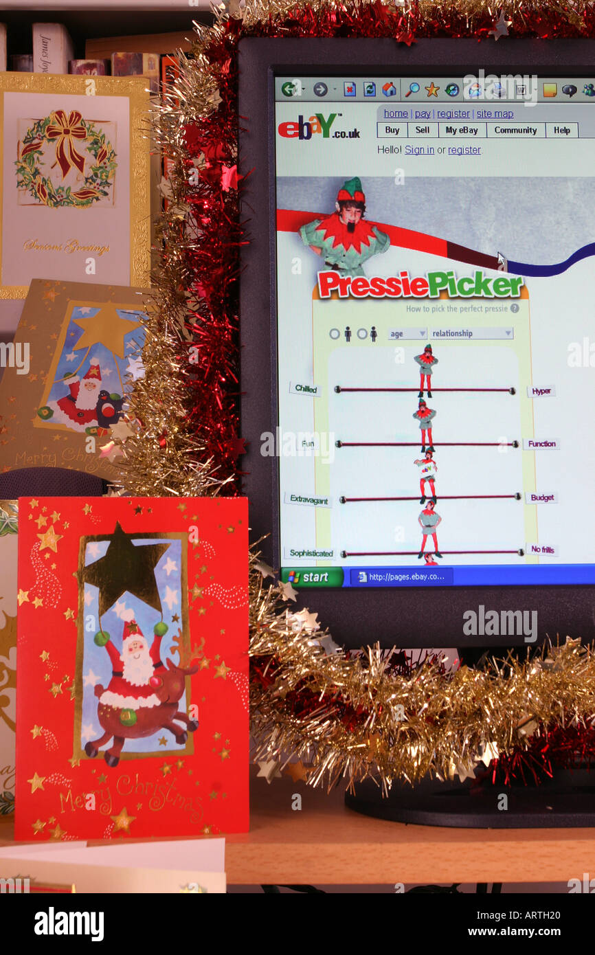 A computer screen decorated with tinsel displaying a Christmas-themed page from the ebay web site with Christmas cards. 2005. Stock Photo