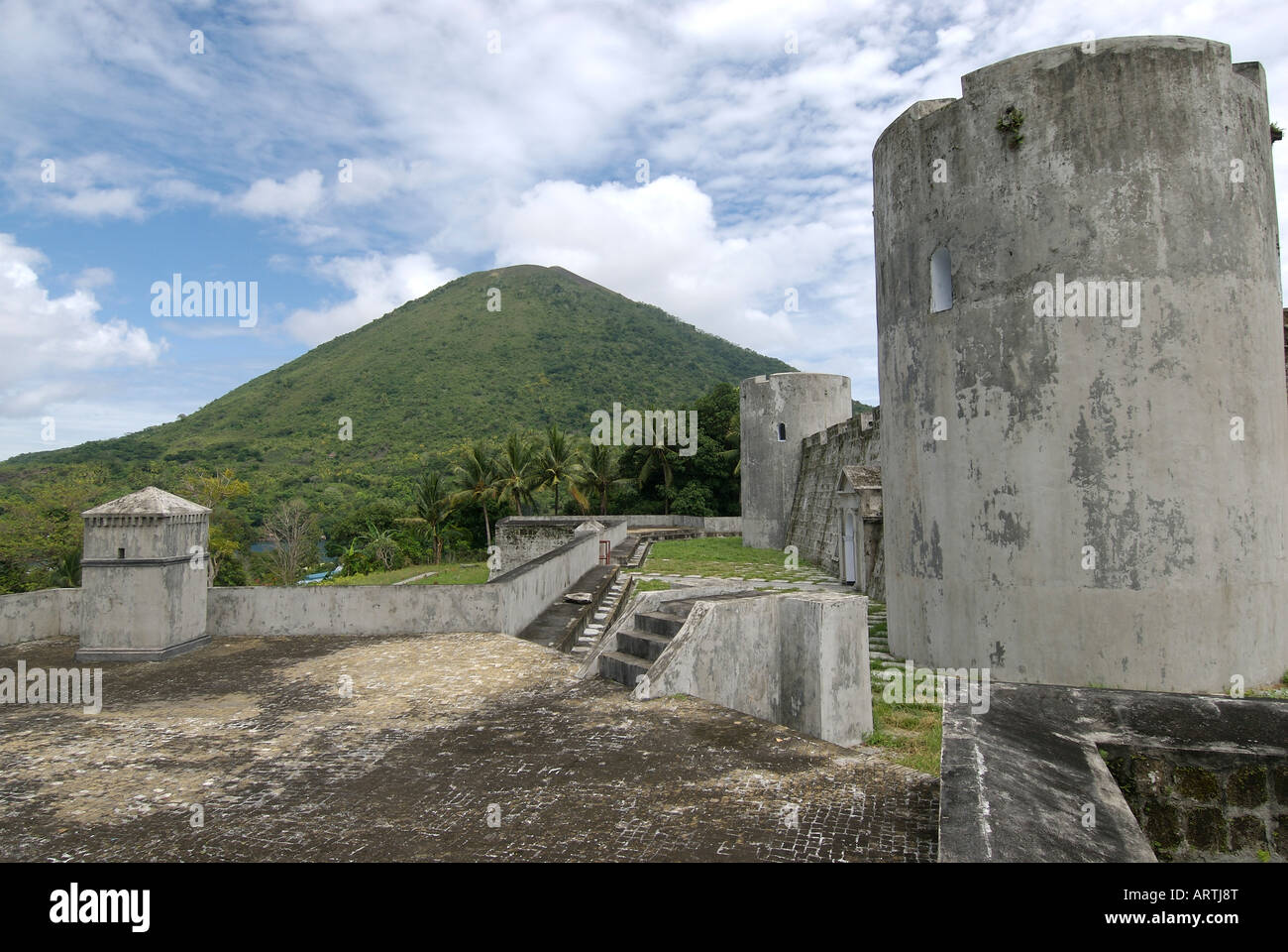 Fort Belgica a relic of the Dutch colonial period in eastern Indonesia with the active volcano Gunung Api in the background Stock Photo