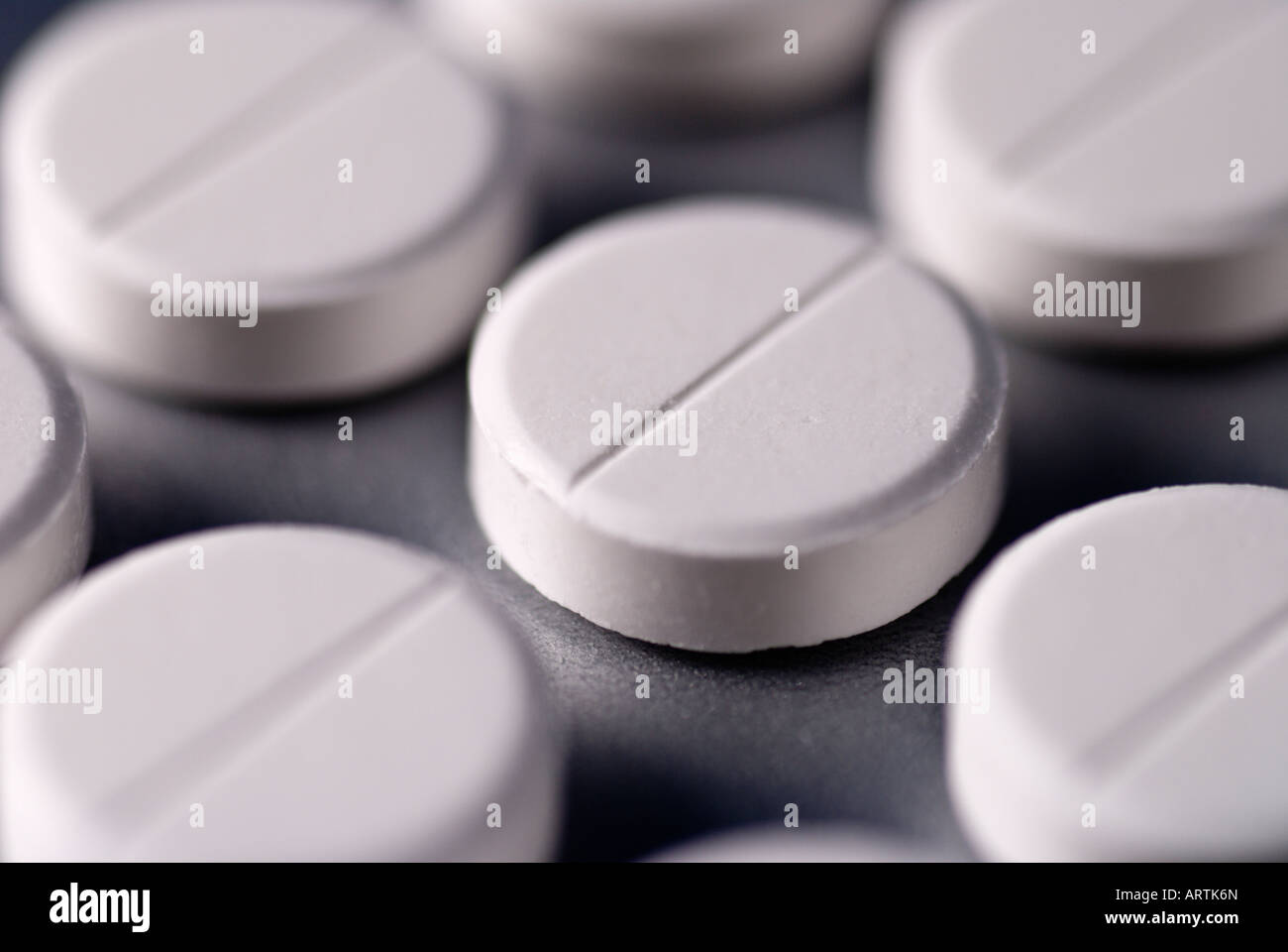 White pills on a silver background. Stock Photo