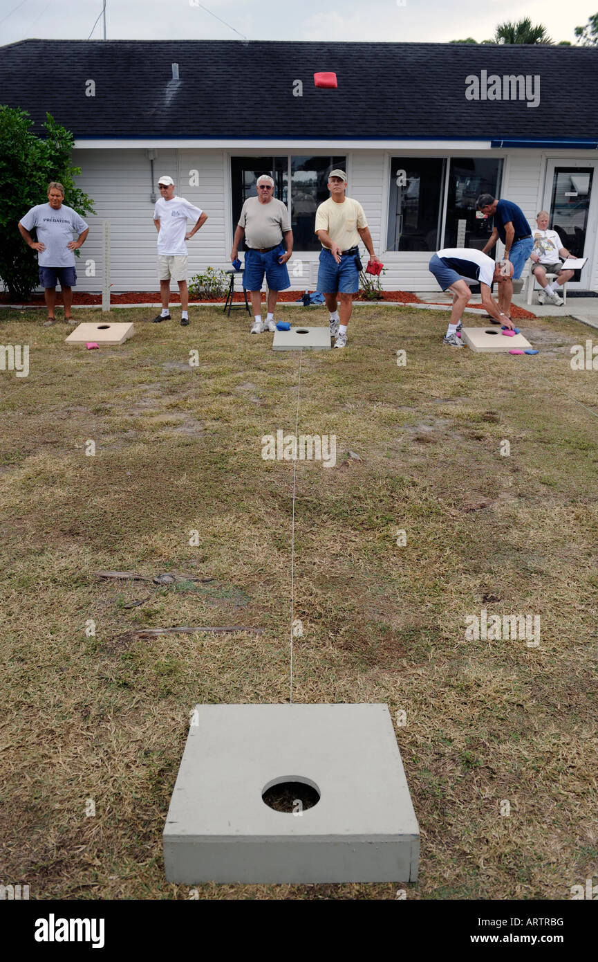 Senior retired citizens play game of bean bag toss in a recreational vechile camping park in