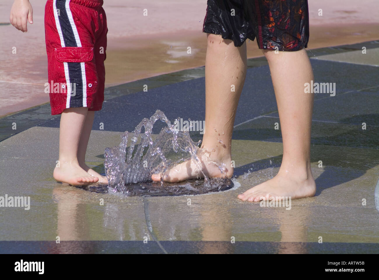 children playing in water fountain at a Florida park cooling off recreation fun wet feet fountains MR Stock Photo