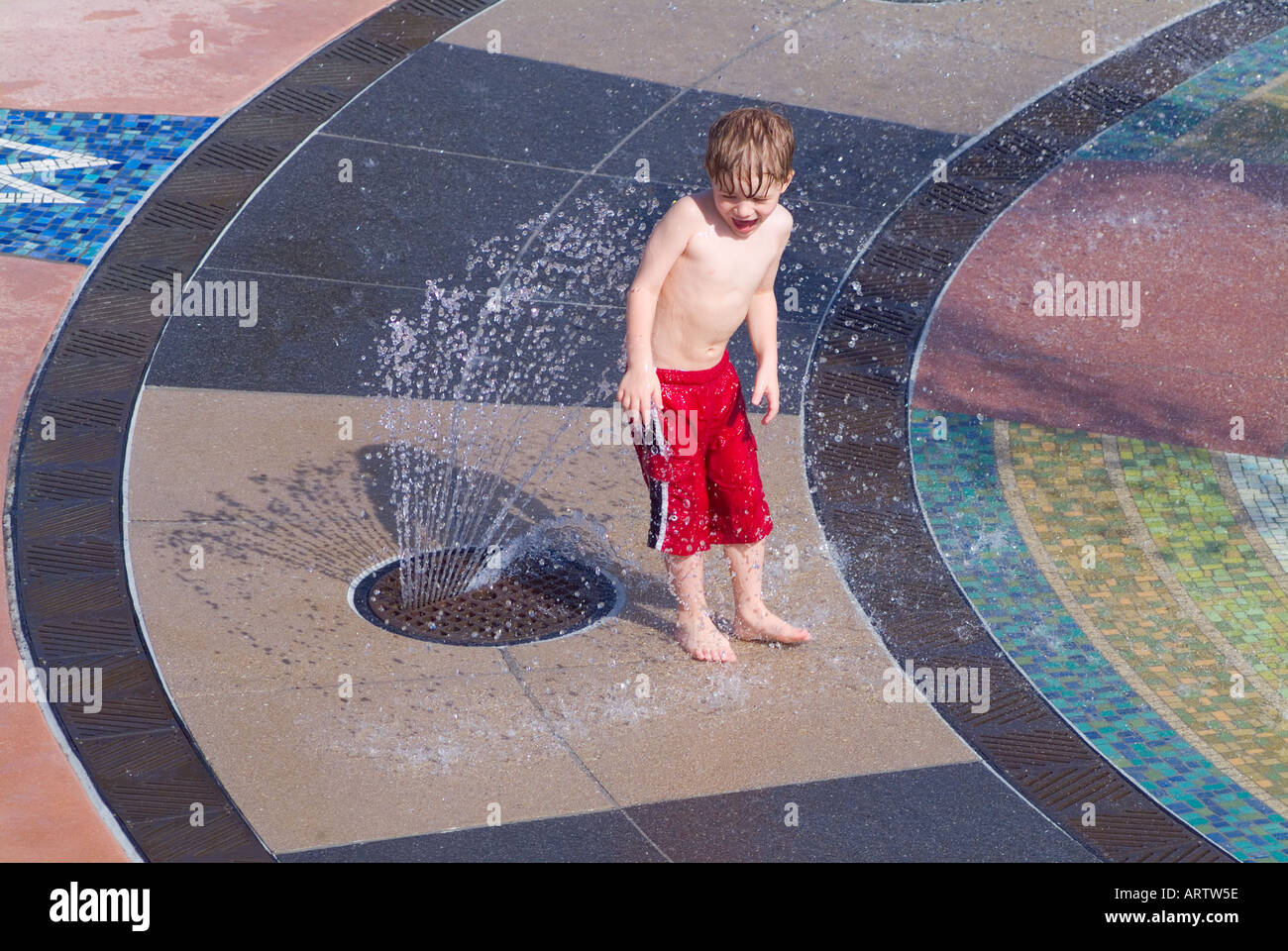 children playing in water fountain at a Florida park cooling off recreation fun wet fountains splash MR Stock Photo