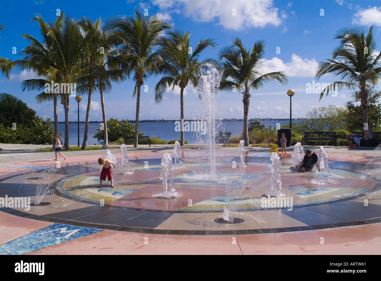 children playing in water fountain at a Florida park cooling off recreation fun wet fountains palm trees Stock Photo